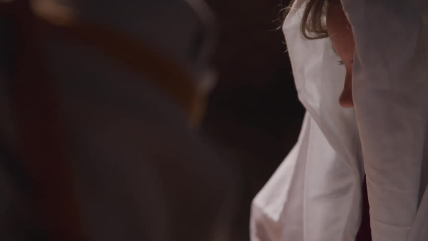 Two people in robes with hoods look down