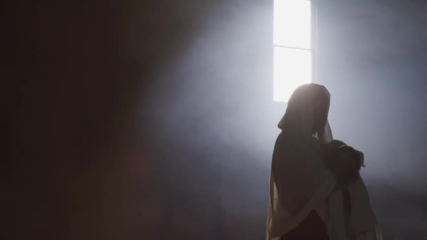 The silhouette stands near the window