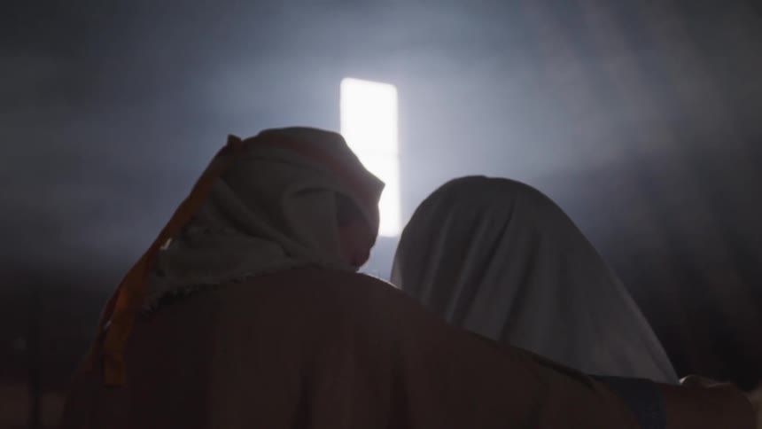 Two people sit side by side in the dark room