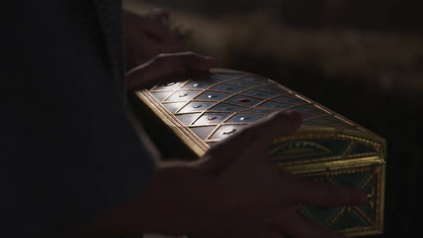 Decorative chest is being held by two hands