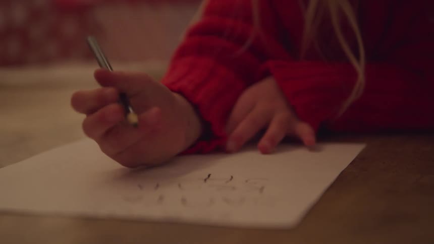 Blonde little girl lying down on the floor writes down
