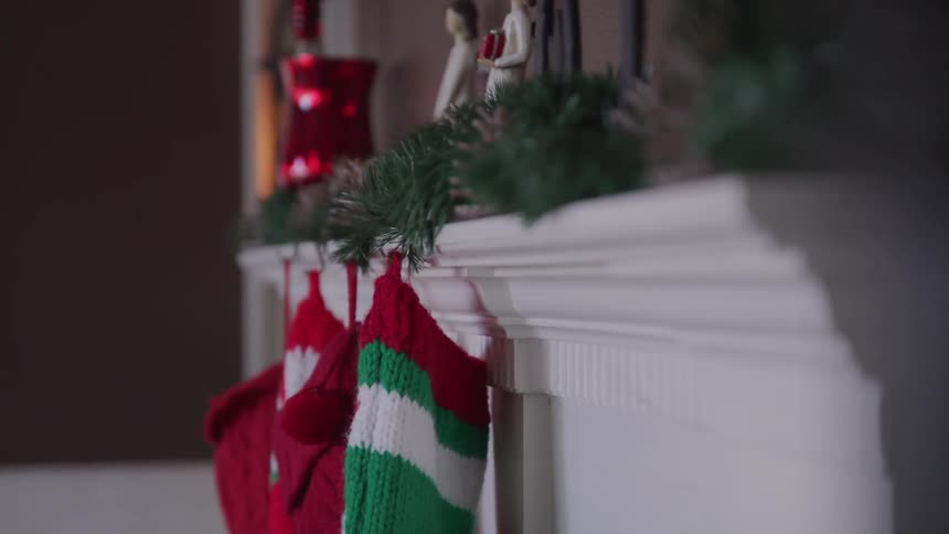 Christmas stockings hang from a decorated mantel