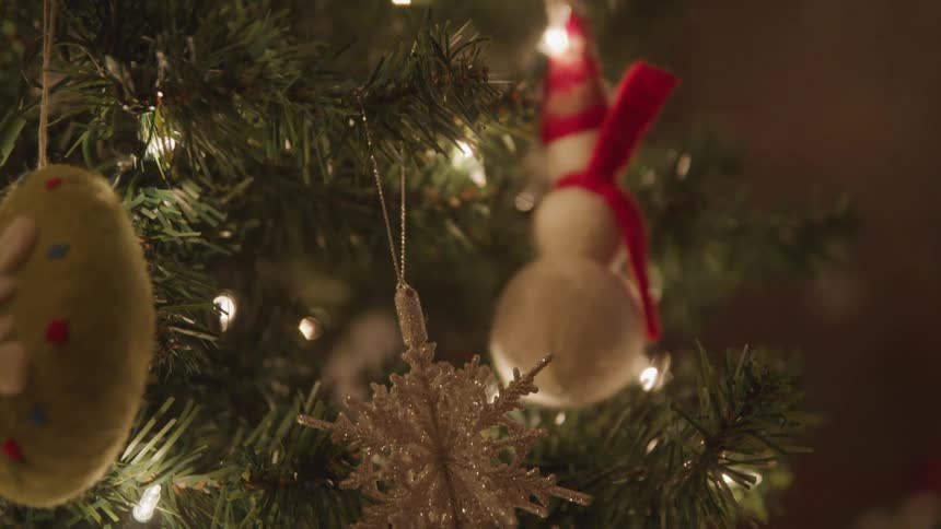 Little girl decorates the christmas tree in the living room at home