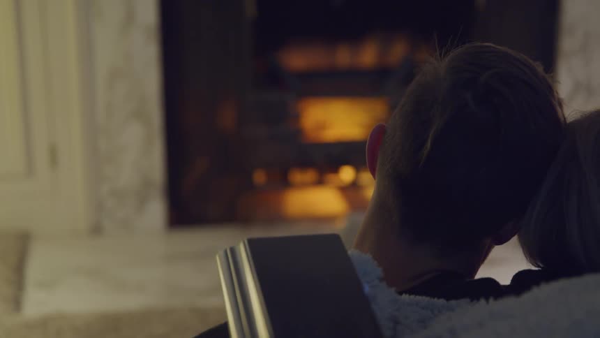 Romantic couple relaxing indoors in front of fireplace