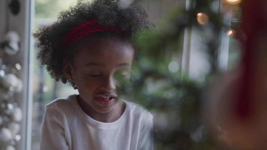 A young girl looks with excitement at a christmas tree