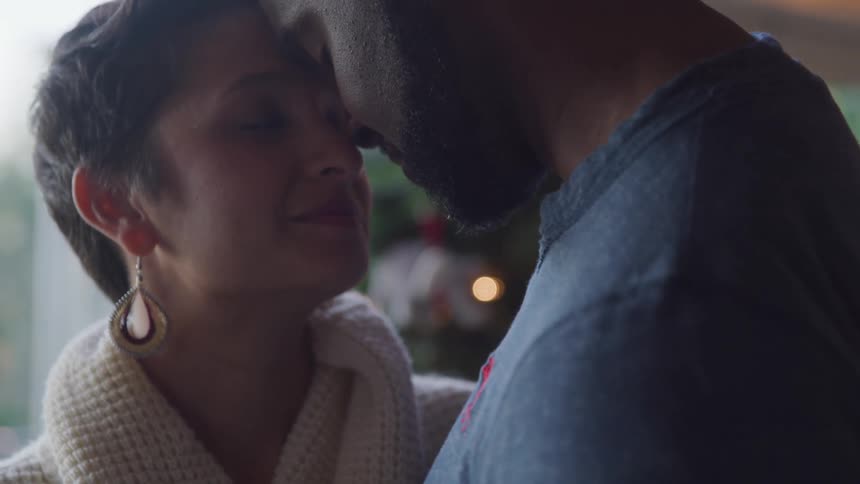 Black man and white woman slowly dancing together with their heads touching in a romantic way