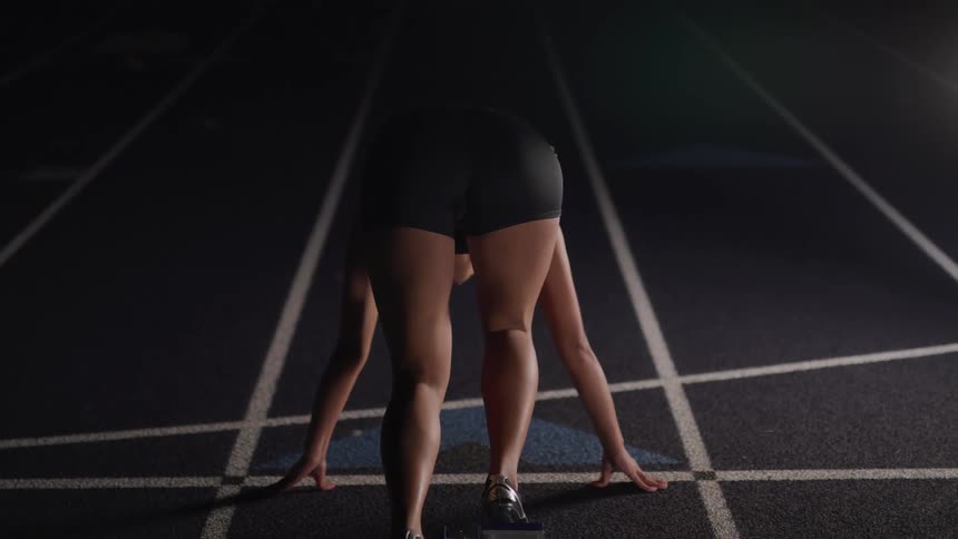Woman starts from starting line and runs along track