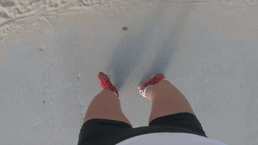 A woman roller skates down a public trail near the beach