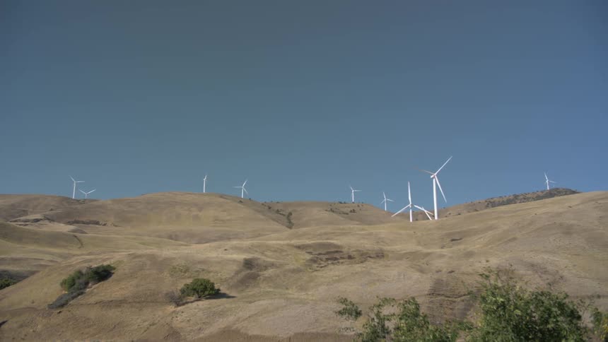 A rural area is displayed with wind mills