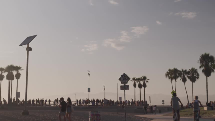 People gathering around and riding bicycles through an outdoor public area