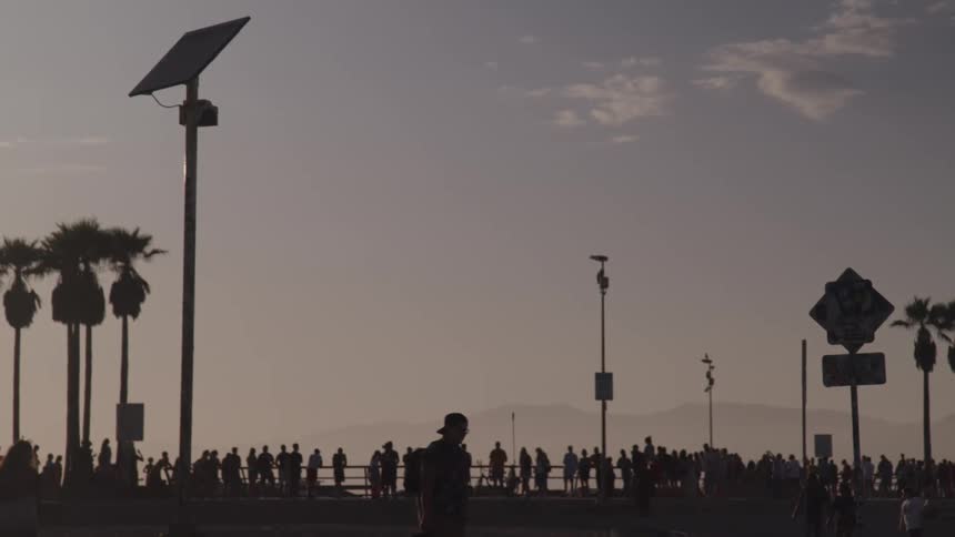 A crowd watches the sunset on the beach
