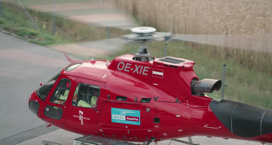 A helicopter on the ground with its propellers rotating