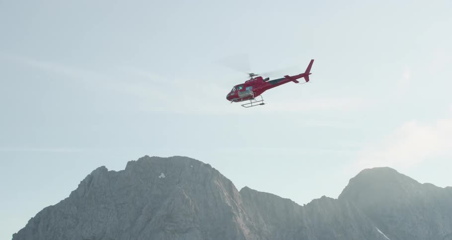 Search and rescue helicopter flies over the mountains