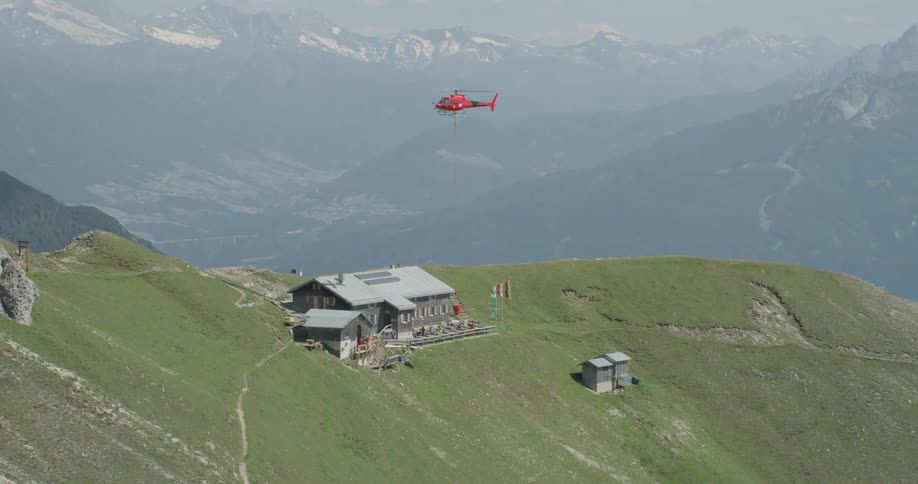 A red helicopter flies high over the resort