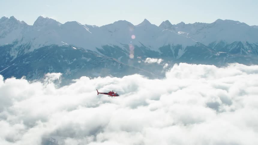The helicopter flies toward the mountains