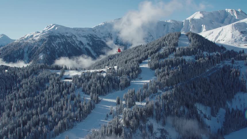 A rescue helicopter flies over the mountains towards a fire