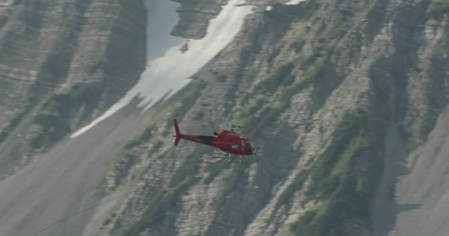 A helicopter is traveling in the sky towards mountains