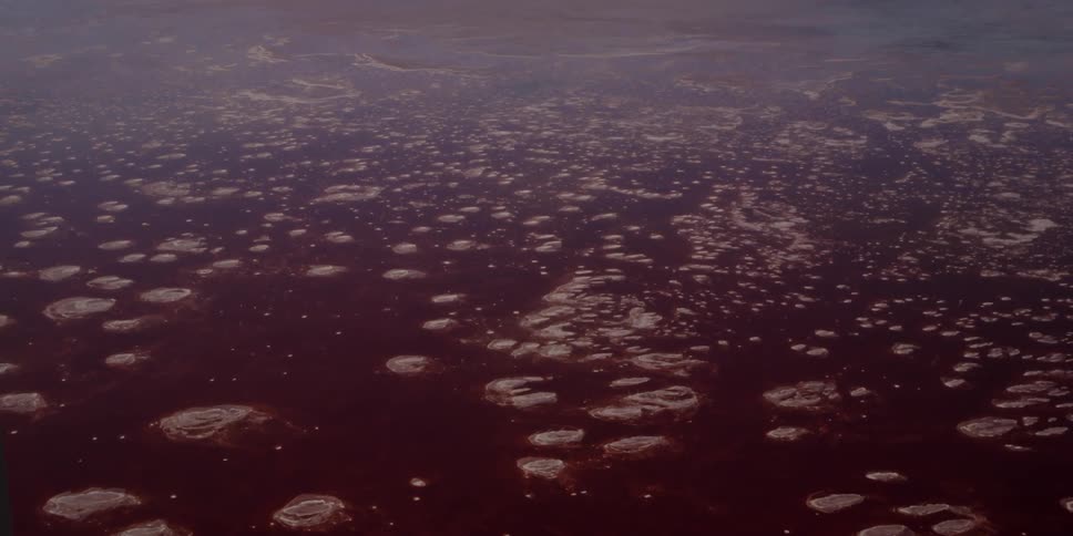 Aerial view of murky waters below with ice floating on top