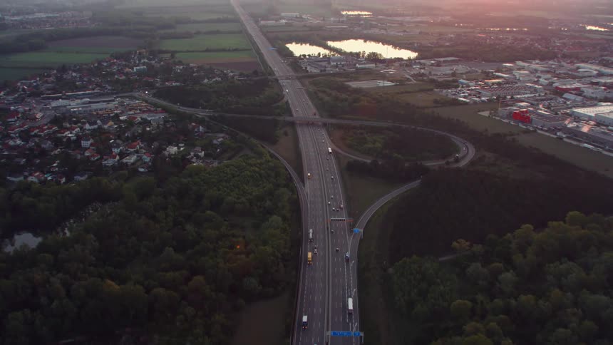 The cars travel on the highway past the town