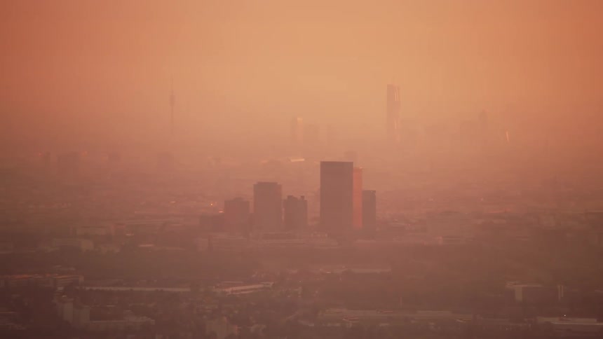 A red fog of air pollution covers a city and skyline