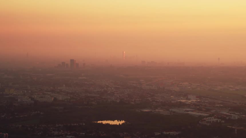 The sun is nearly set behind the city ahead
