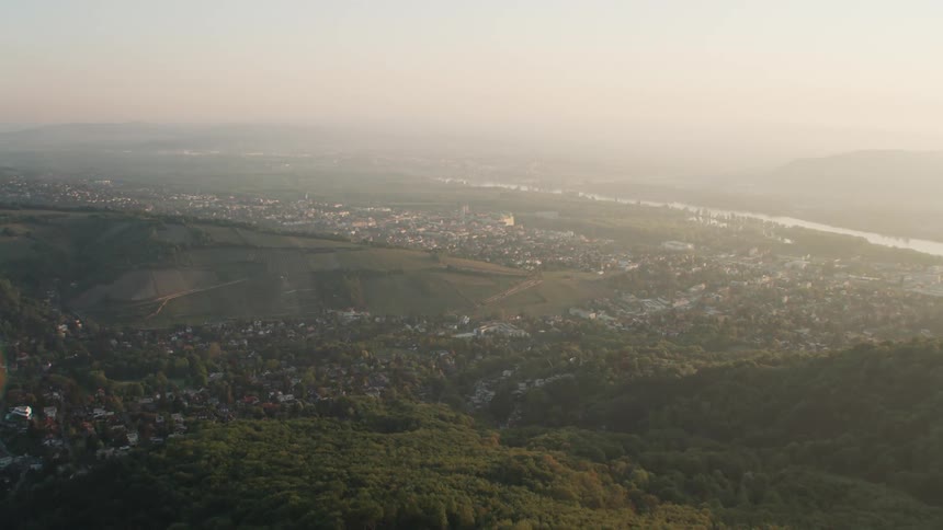 Aerial view of the distant foggy city next to the river