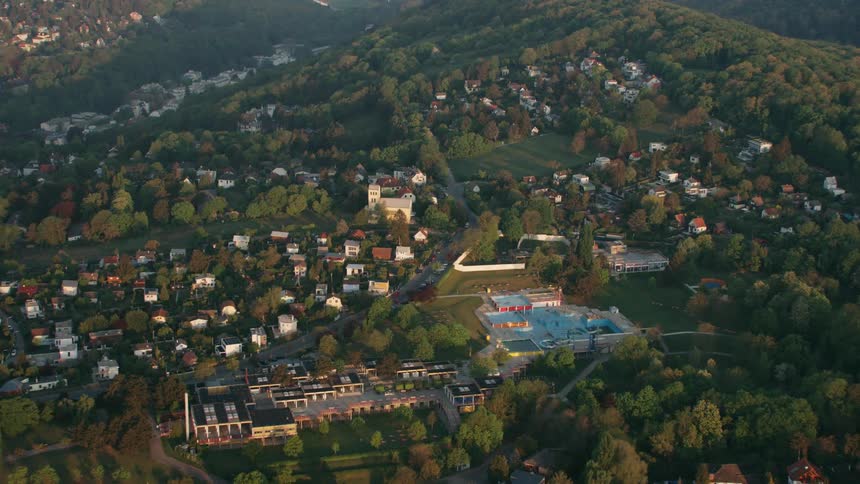 An aerial view of homes and neighborhood on hills and an empty waterpark