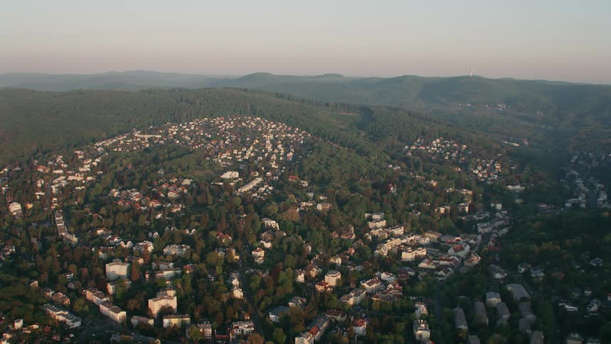 The green hills are lined with homes and buildings