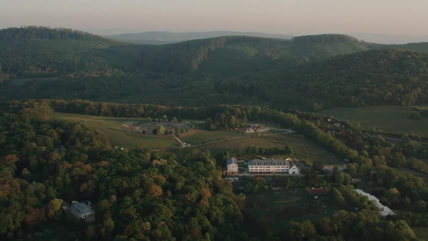 Buildings and homes with farm fields built on green hills and ridges