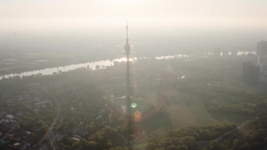 Sunshine brightens fog obscuring city and river