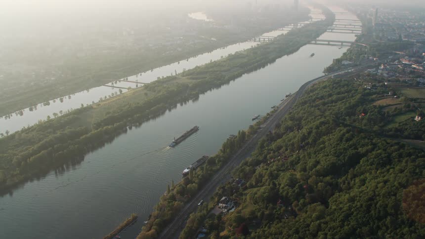 The ship travels down the river on a foggy day