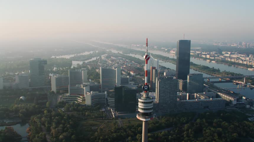 A large needle tower is before the city