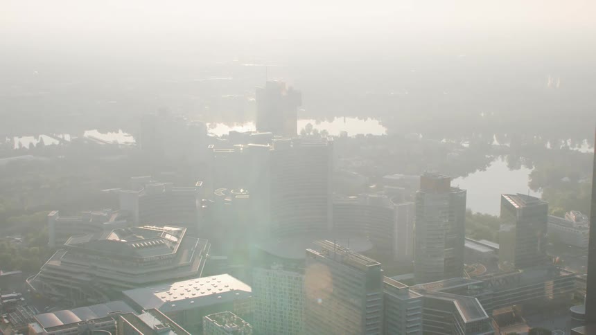 Aerial view of a foggy city with tall office buildings and skyscraper