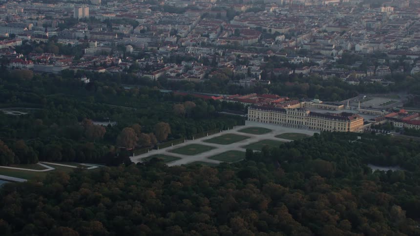 A large building with a larger courtyard on the outskirts of a city