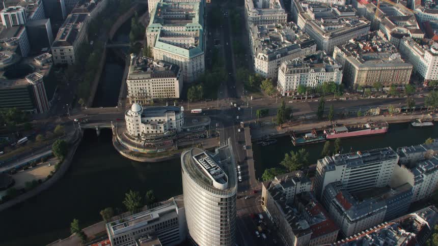 An aerial view of cars traveling on a city street near buildings and skyscrapers