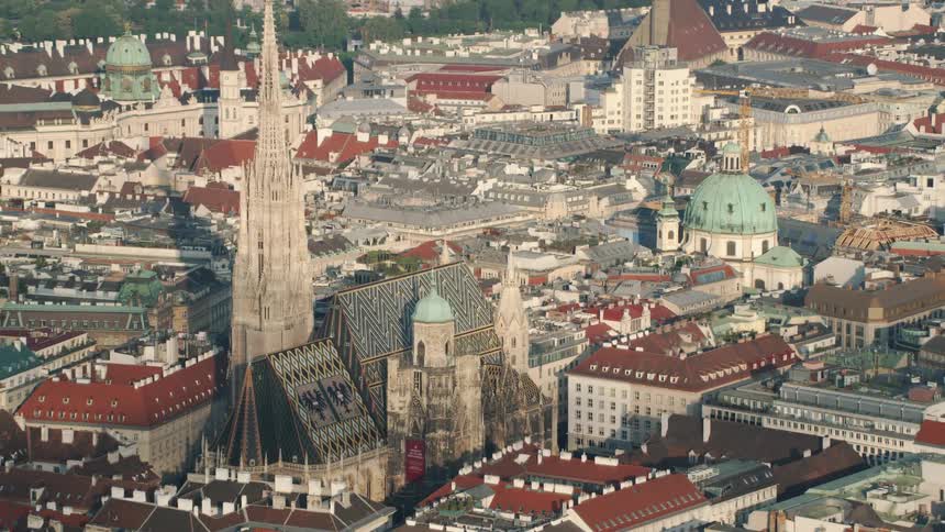Aerial view of city rooftops and church spire and dome