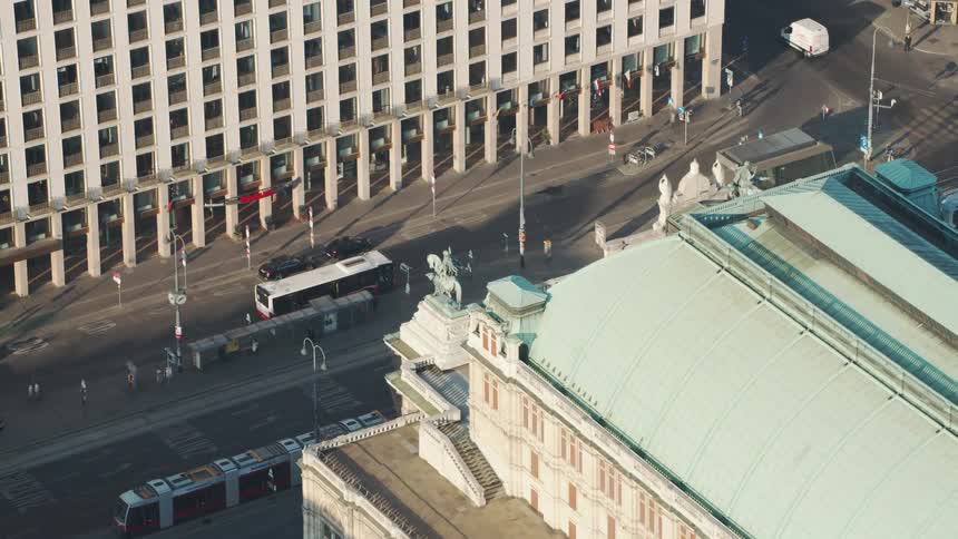 A busy city street with people cars buses and trains on it
