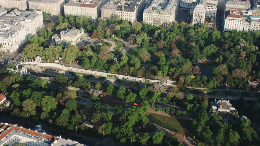 An aerial view of a city nearby a forest is displayed