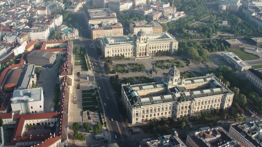 Vehicles drive past buildings in the city