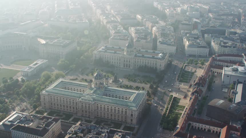 The vehicles travel down the avenue of the city