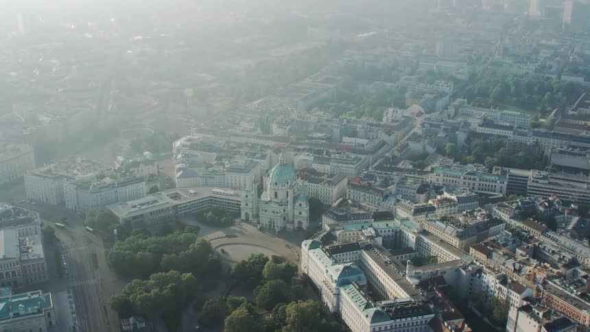 Domed building surrounded by offices or dorms in large city under fog