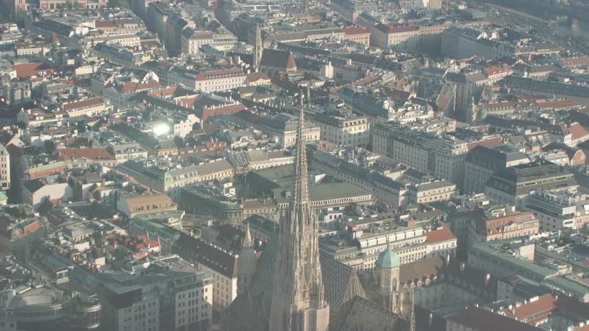 A large steeple on a church in the middle of a big city