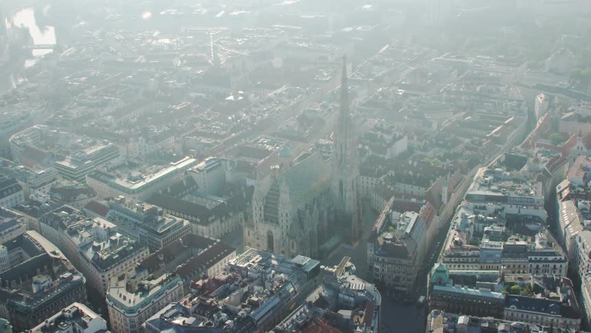 Fog covers cathedral occupying center of sprawling city bordering river