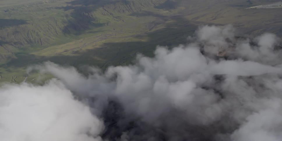 Aerial view of clouds traveling over a field