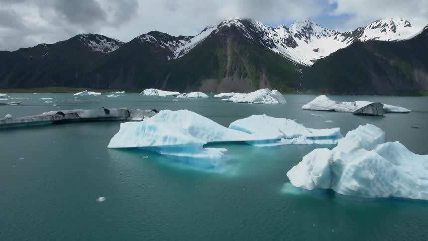 Large chunks of ice in a lake by the mountains