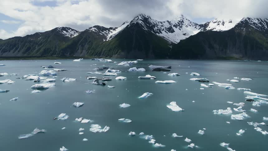 Ice in a lake in front of a snow covered mountain