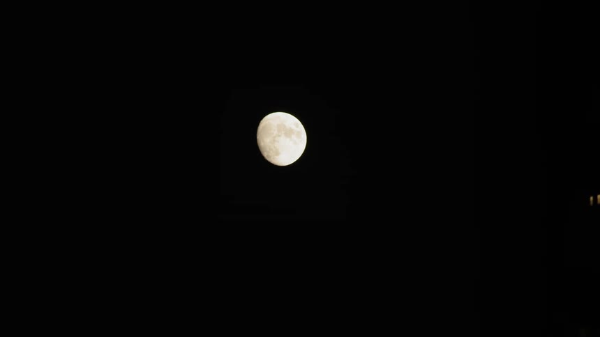 Moon hangs over building and street