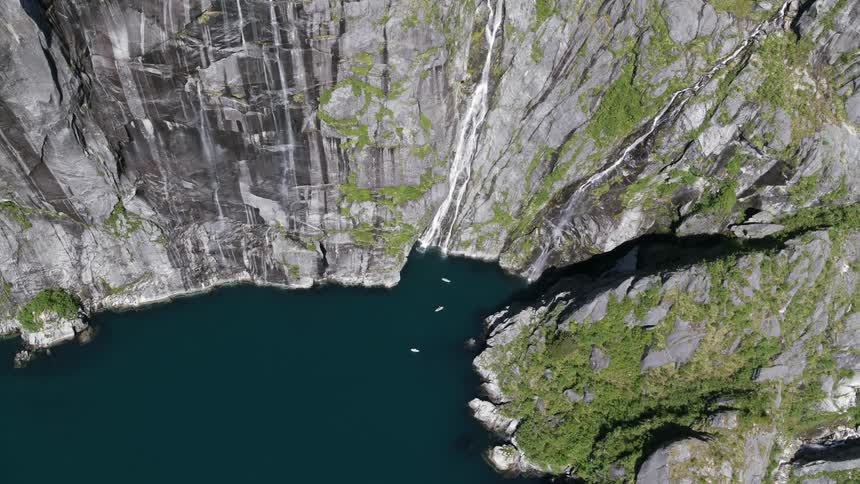Small boats sit in a lake nestled in a canyon