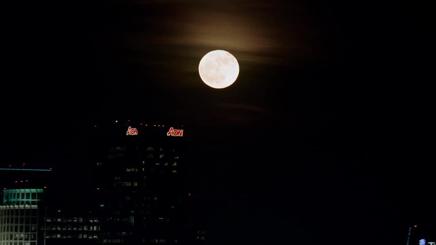 A city skyline of multinational banks and the moon