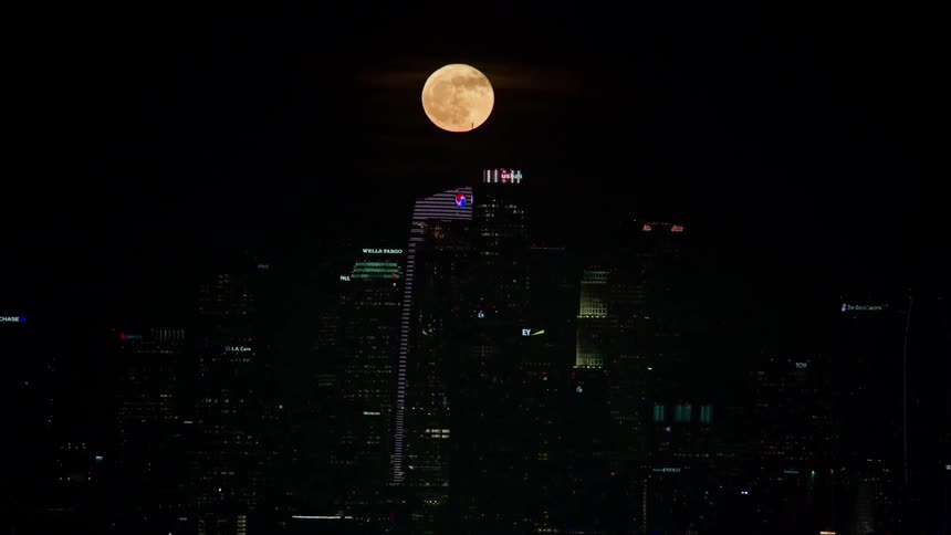 Full moon over city skyline at night